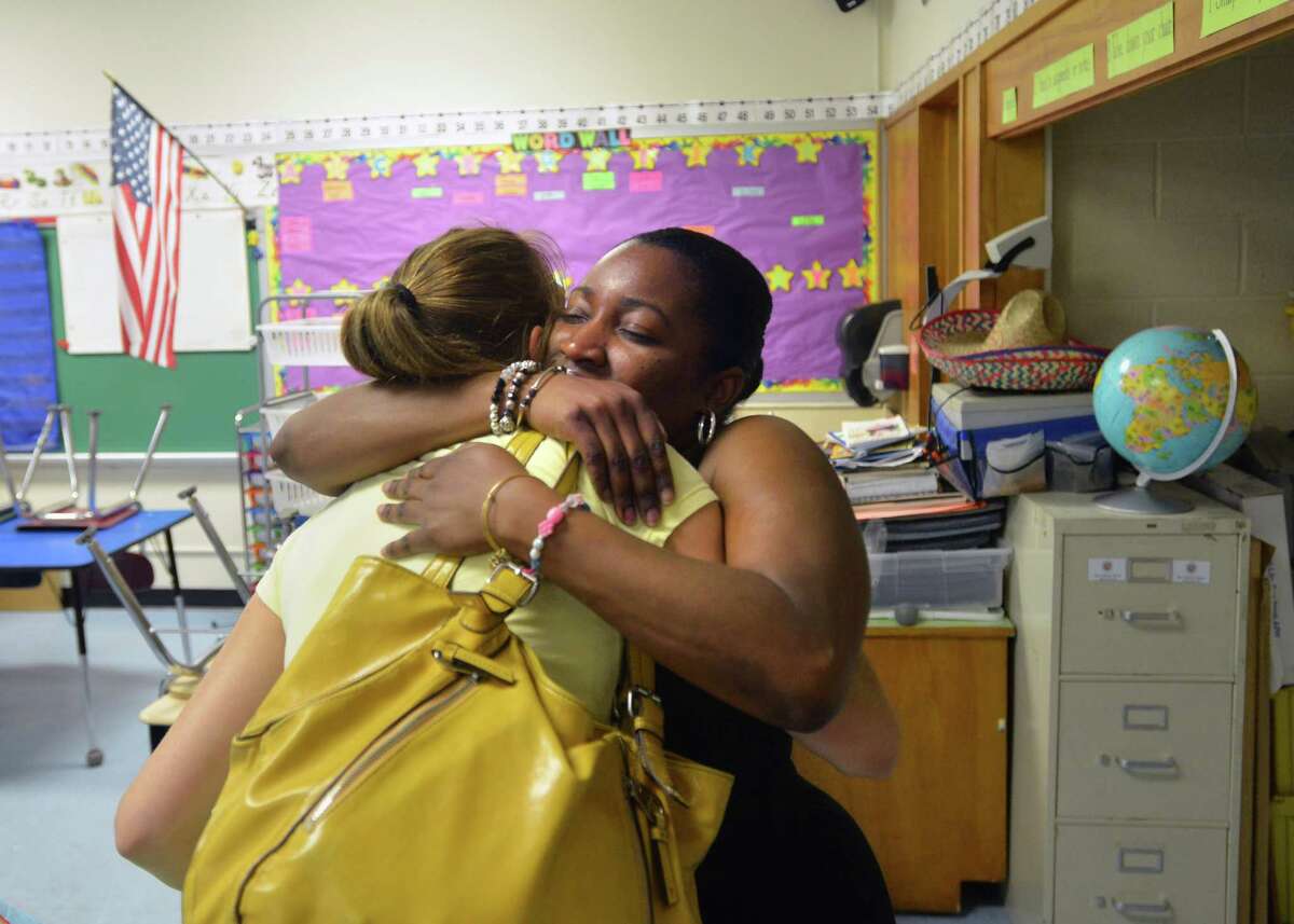 At right, Lisa Moore, a New Lebanon School second-grade teacher, hugs New Lebanon School first-grade teacher, Elaina Weaver, on the last day of the school year for staff in the Greenwich school district, Thursday, June 27, 2013. Weaver said that she is leaving the school after eight years as a first-grade teacher but will be staying in Greenwich continuing as an elementary school teacher at North Minaus School when the new school year begins on August 27.