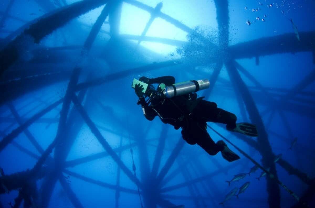 A diver explores former offshore oil equipment that has been turned into an artificial reef in the Gulf of Mexico. New federal rules may mean more such rigs will be turned to reefs in Texas waters.