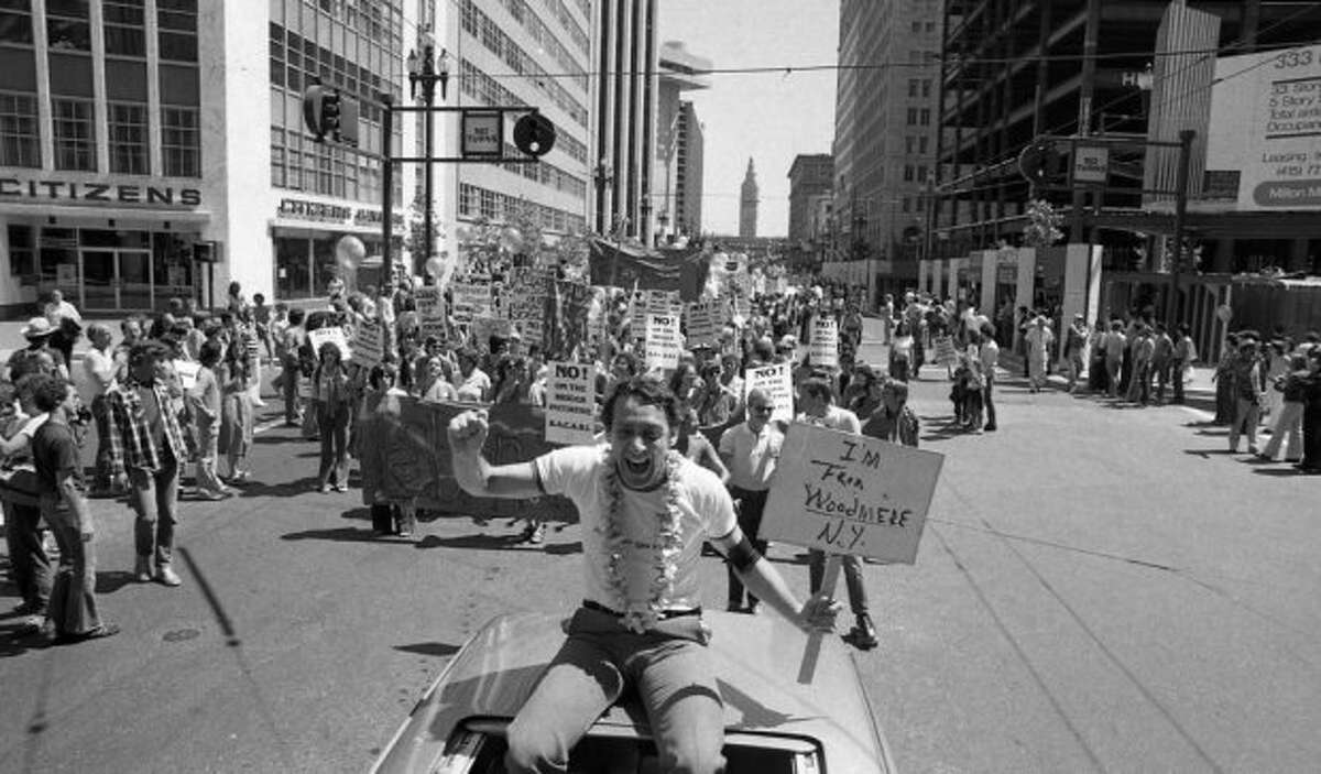 June 25, 1978: Supervisor Harvey Milk with the Ferry Building in the background during the Gay Freedom Day Parade in 1978.