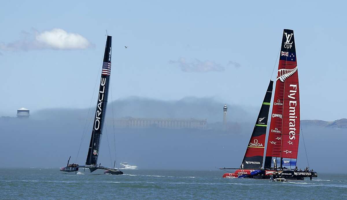 Emirates Team New Zealand, right, and Oracle Team USA, left, sail near Alcatraz Island in the fog during training for the America's Cup Wednesday, June 26, 2013 in San Francisco. Opening ceremonies for the sailing event are on July 4. (AP Photo/Eric Risberg)