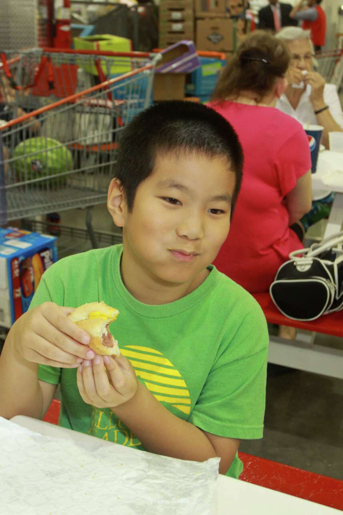 Albert Ma, 8, enjoys a hot dog. Costco says it sells 110 million hot-dog-and-soda combos a year, at $1.50 each.