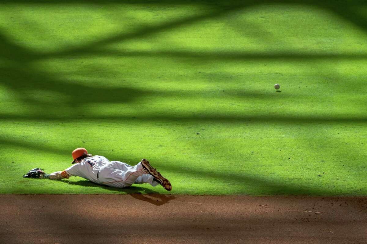 Astros shortstop Jake Elmore can't make the play on a single by the Angels' Mark Trumbo during the ninth inning at Minute Maid Park on Saturday. It was a tough day for Elmore (0-for-4 with two errors) and the Astros (a 7-2 loss, their 51st of 2013).