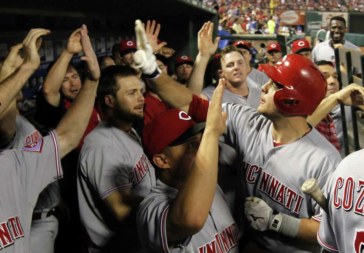 Cincinnati's Devin Mesoraco (right) exchanges high-fives after his 11th-inning, two-run homer.
