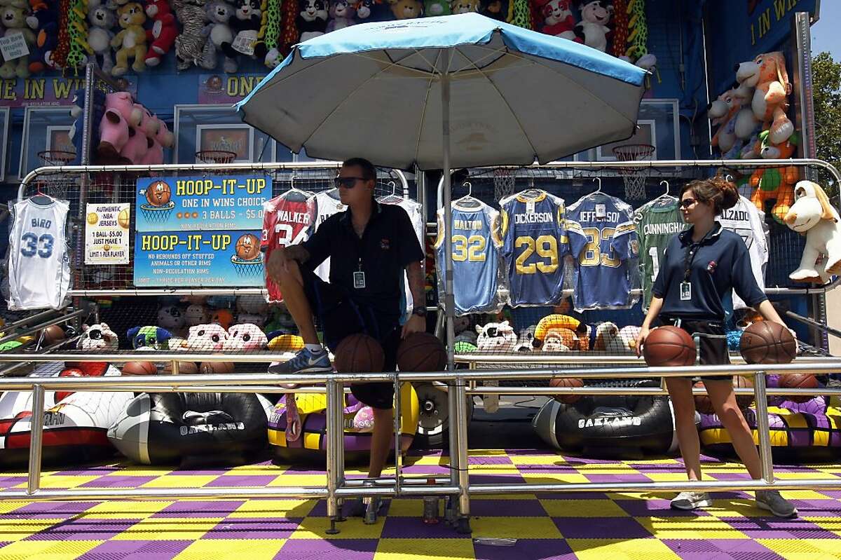 Joshua Clabaugh and Tera Weber wait for people to play on a scorching day at the Alameda County Fair on Sunday, June 30, 2013 in Alameda County, Calif.