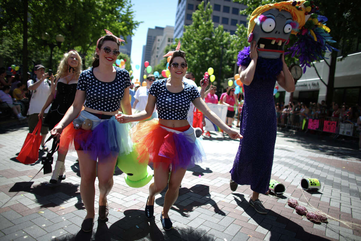 Sara Koelsch, left, and Jenny Glatt march with PopCap Games during the annual Pride Parade on Sunday, June 30, 2013 in Seattle. Hundreds of thousands of people came to downtown Seattle to celebrate Pride, on the heels of a U.S. Supreme Court decision on DOMA and California's Proposition 8 and last year's legalization of same-sex marriage by voters in Washington State.