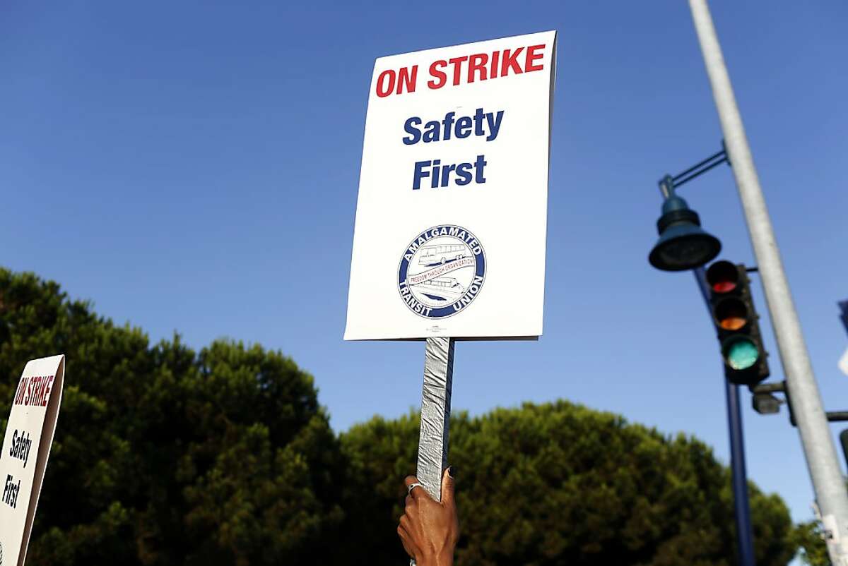 A picketer raises a sign during strikes against BART outside of the West Oakland BART station in Oakland, Calif. on July 1, 2013.