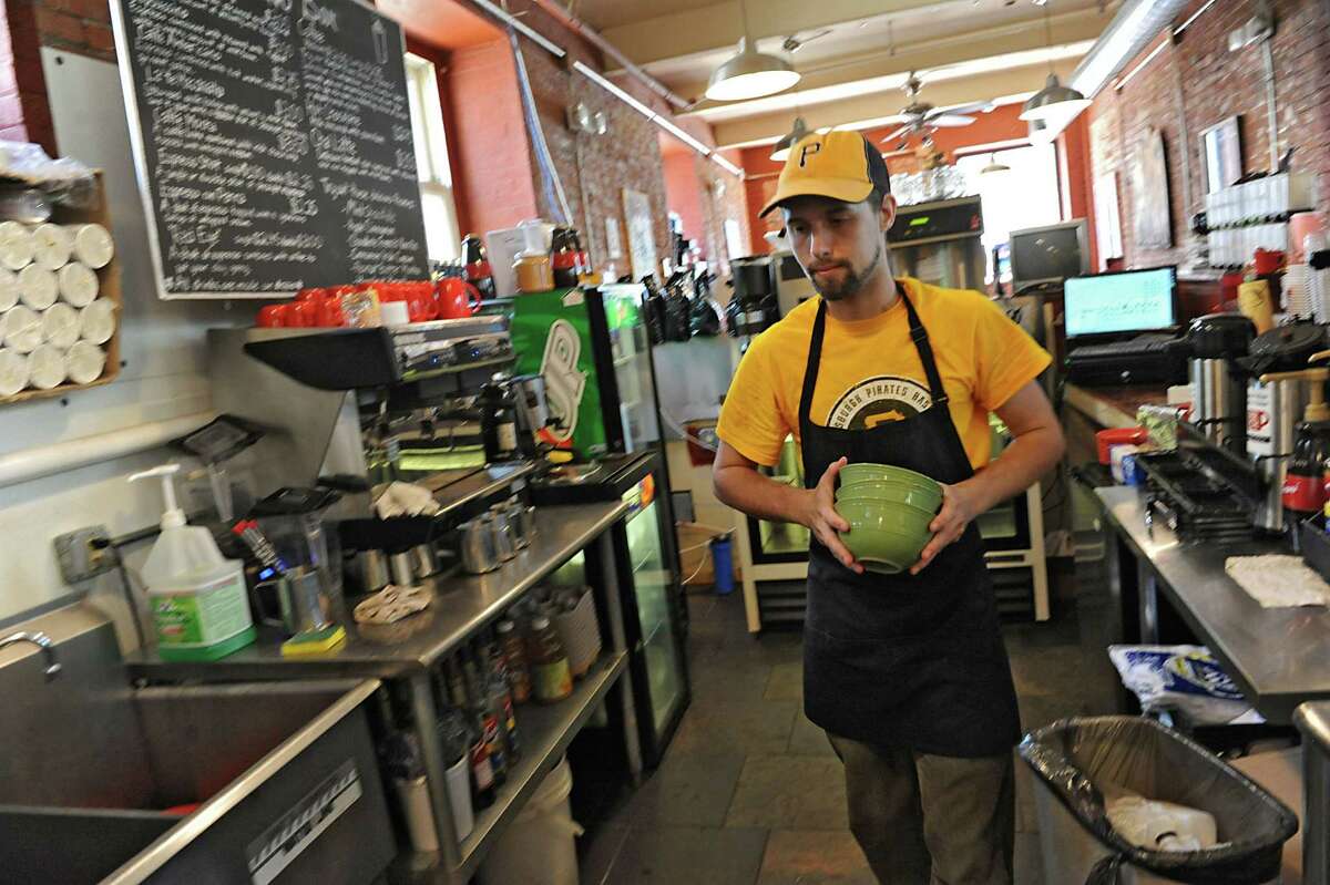 Anton Pasquill works behind the counter at the Hudson River Coffee House on Quail St. on Friday, June 21, 2013 in Albany, N.Y. With college students gone for the summer, he's experiencing slower business. (Lori Van Buren / Times Union)