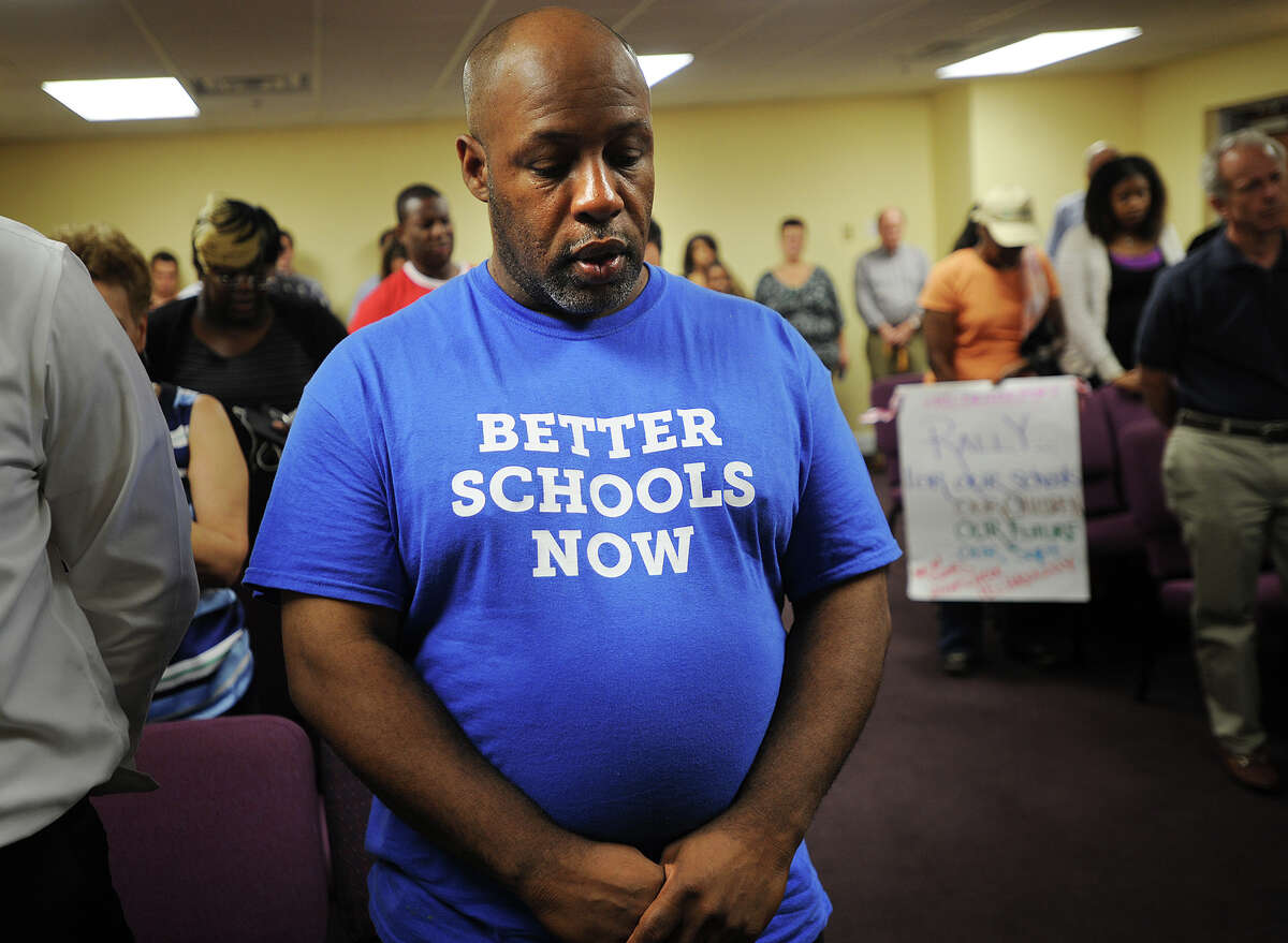 Father to eleven children, Leon Woods, of Bridgeport, bows his head in prayer during a rally supporting former Supt. of Schools Paul Vallas at the Cathedral of the Holy Spirit at 790 Union Avenue in Bridgeport, Conn. on Monday, July 1, 2013.