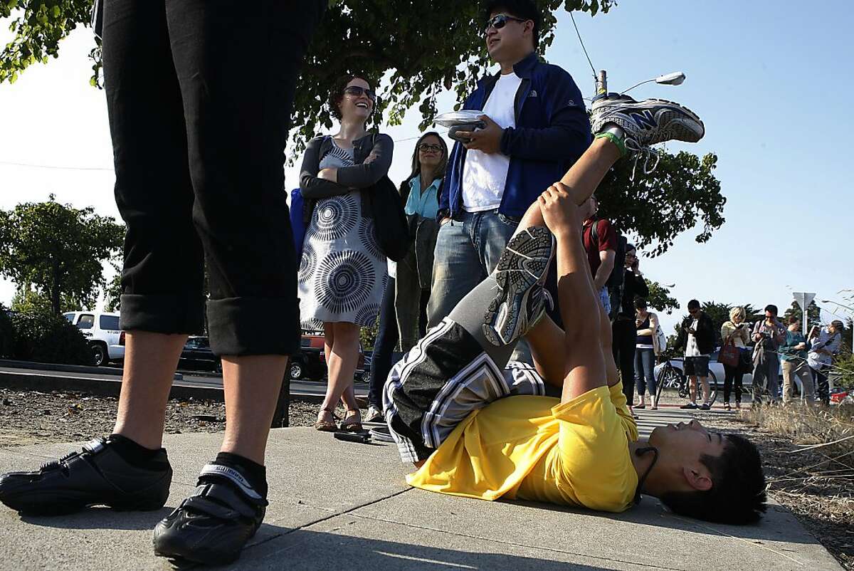 David Truong (right) from Alameda stretches while waiting for the Alameda ferry to arrive in Alameda, Calif., on Tuesday, July 2, 2013, as BART remains on strike. A software engineer commuting to Zynga, David runs 2 miles to the ferry from home and 2.5 miles from the San Francisco ferry to work.