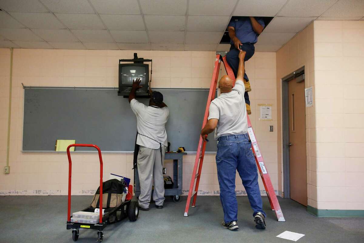 Workers dismantle a classroom as HISD takes over North Forest ISD's Fonwood Elementary School, July 2, 2013 in Houston.