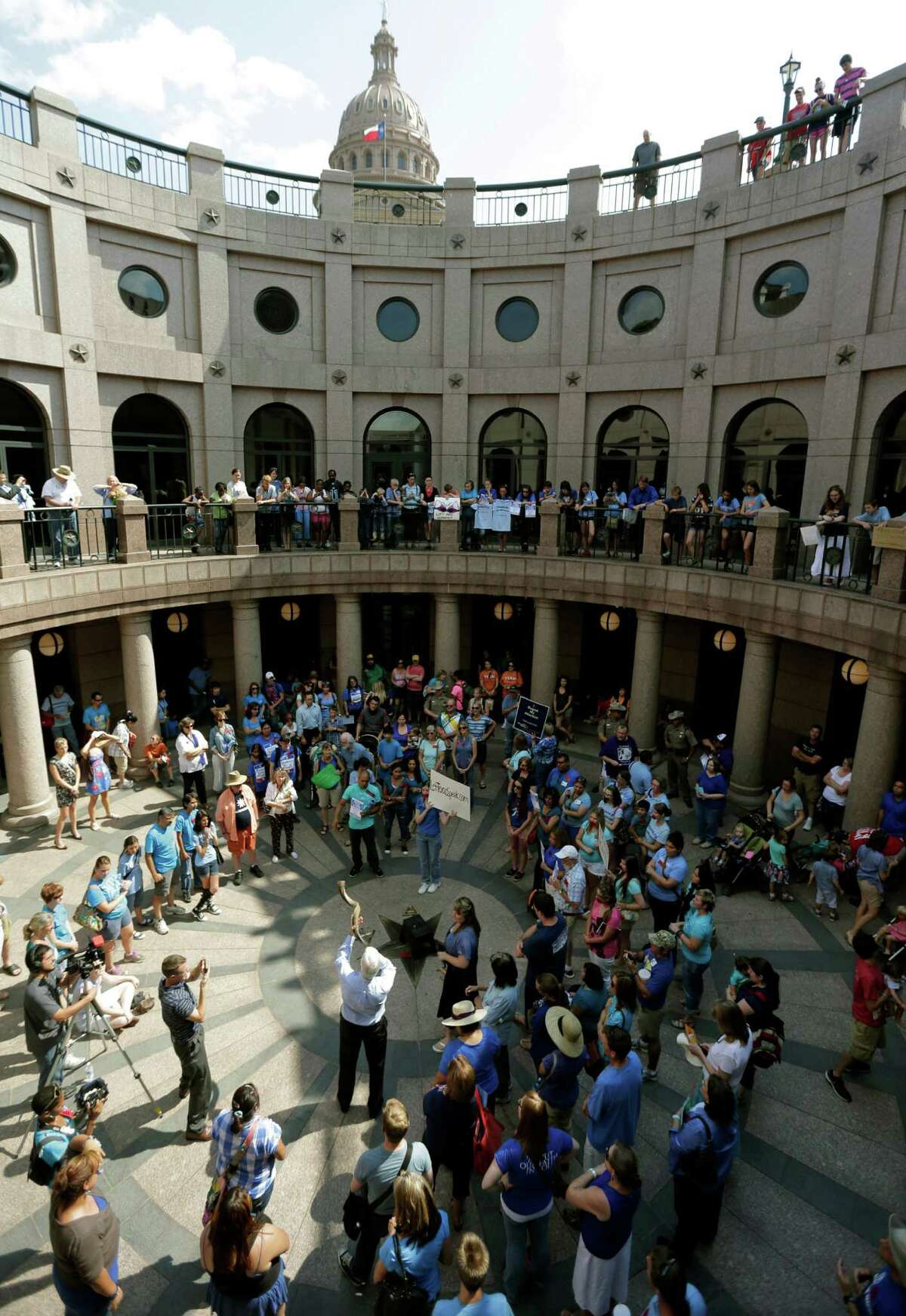 A man blows a horn as supporters and opponents of an abortion bill gather in a near a hearing for the bill at the state capitol, Tuesday, July 2, 2013, in Austin, Texas. Gov. Rick Perry has called lawmakers back for another special session with abortion on the top of the agenda.
