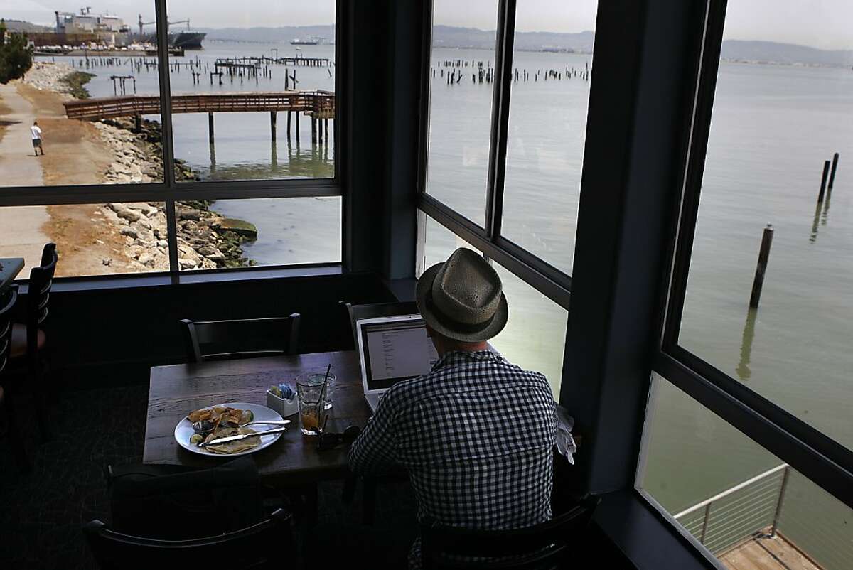 Tommy Becker from San Francisco has lunch and an iced tea while surfing the net at Mission Rock Resort in San Francisco, Calif.,on Monday, July 1, 2013.