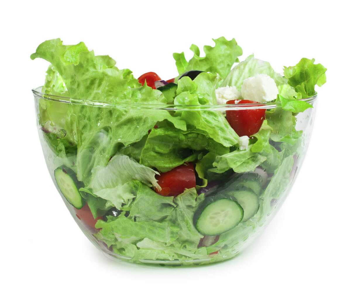 Mixed salad in a glass bowl on a white background/fotolia