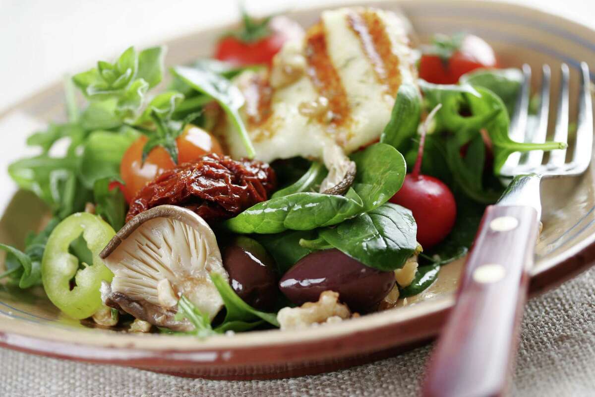 salad with mushrooms,spinach,tomatoes,sundried tomatoes,walnuts,haloumi cheese/fotolia