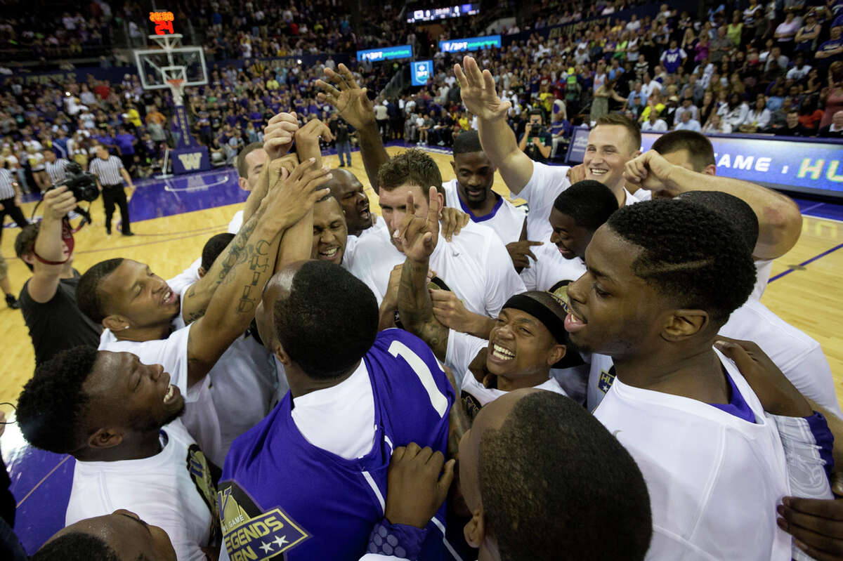 Isaiah Thomas, center right, is mobbed by teammates at the beginning of the University of Washington Alumni Game Sunday, June 23, 2013, in the Alaska Airlines Arena at the University of Washington in Seattle, Wash. The after-2009 team, in purple, beat the pre-2009 team, in white, 107-104.