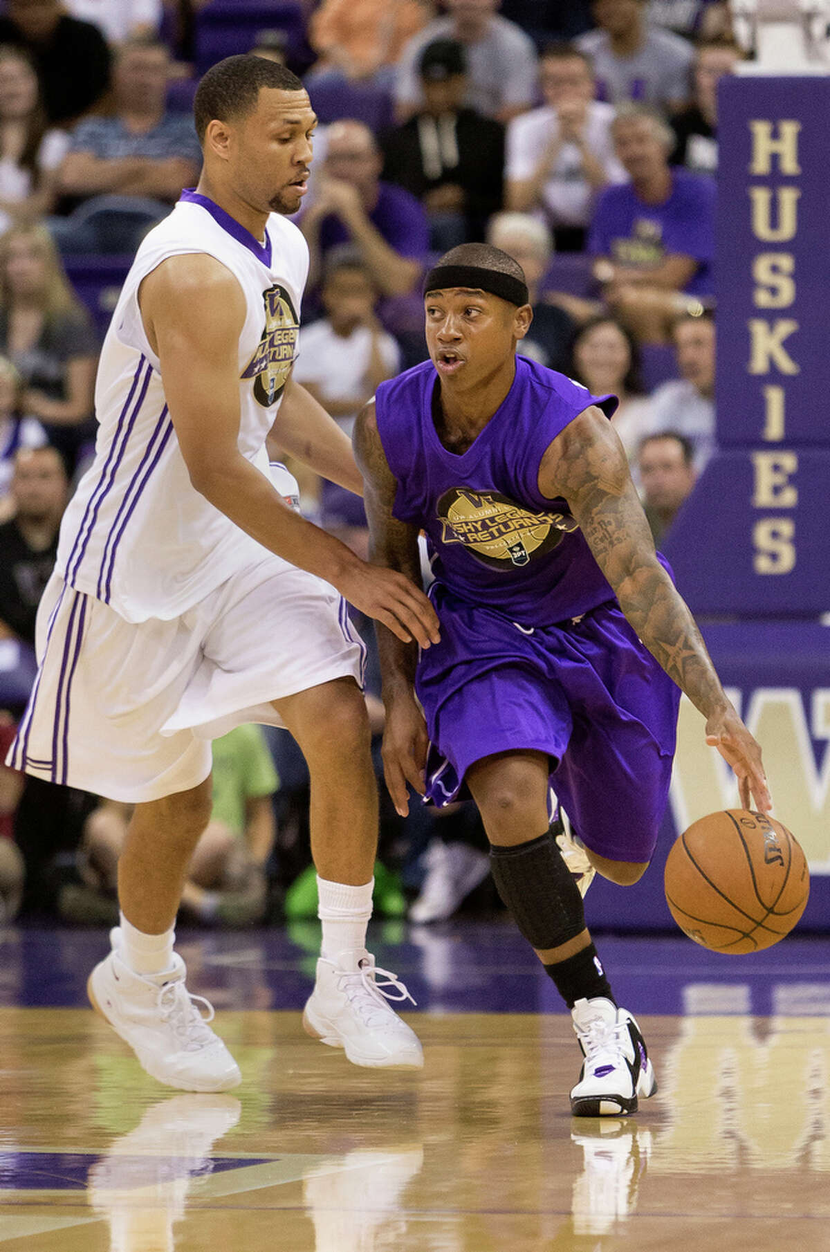 Isaiah Thomas, right, pushes past Brandon Roy, left, during the University of Washington Alumni Game Sunday, June 23, 2013, in the Alaska Airlines Arena at the University of Washington in Seattle, Wash. The after-2009 team, in purple, beat the pre-2009 team, in white, 107-104.