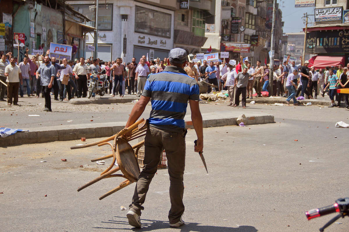 An Egyptian opposition protester holds a chairr and knife during a clash between supporters and opponents of President Mohammed Morsi in downtown Damietta, Egypt, Wednesday, July 3, 2013. he deadline on the military's ultimatum to President Mohammed Morsi has expired, with 48 hours passing since the time it was issued. Giant cheering crowds of Morsi's opponents have been gathered in Cairo's Tahrir Square and other locations nationwide, waving flags furiously in expection that the military will act to remove the Islamist president after the deadline ends.