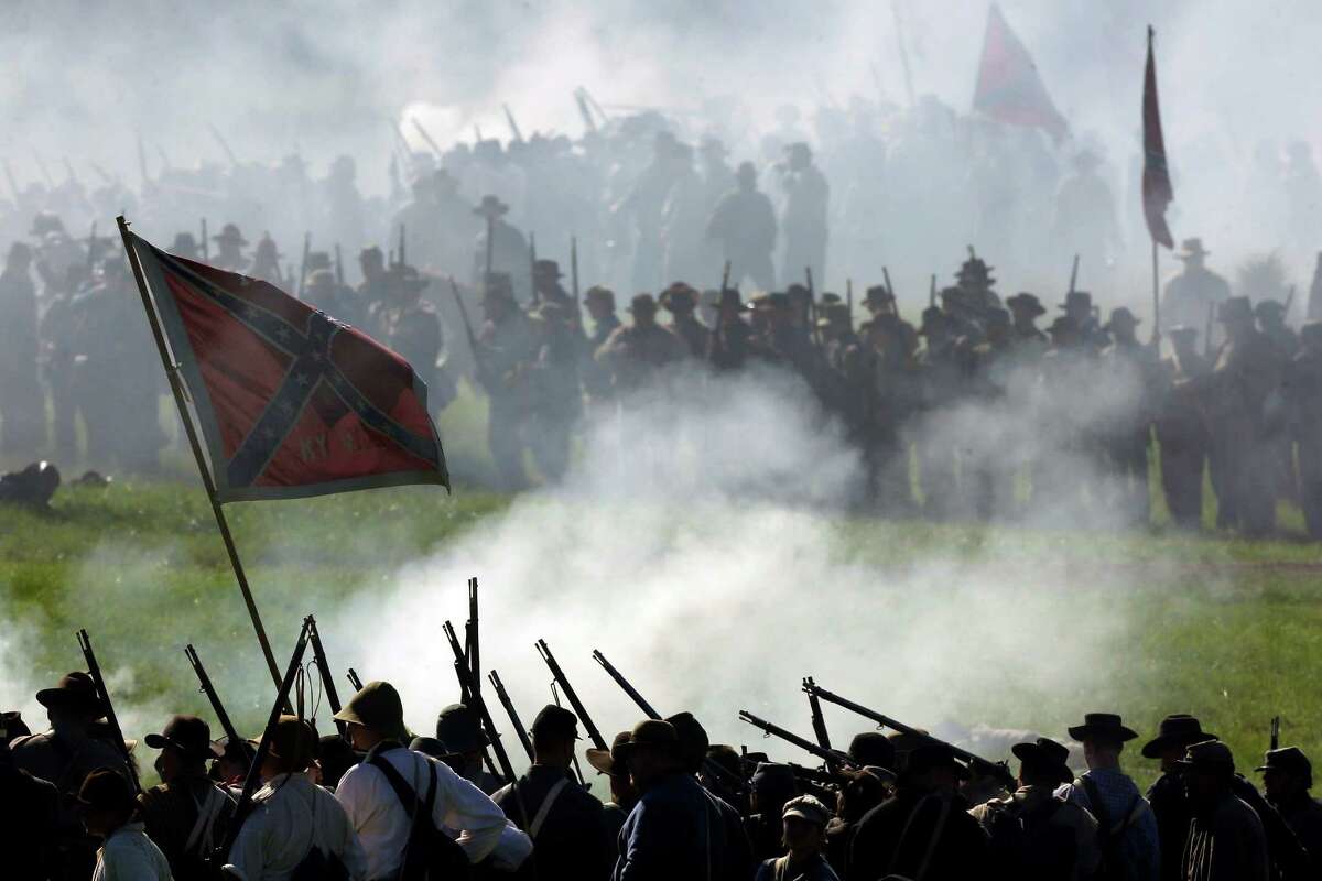 In this June 29, 2013 file photo, Confederate re-enactors take part in a demonstration of a battle during ongoing activities commemorating the 150th anniversary of the Battle of Gettysburg at Bushey Farm in Gettysburg, Pa. One of the most difficult challenges for any mock general at a Civil War battle re-enactment is deciding which of his men must "die." (AP Photo/Matt Rourke)