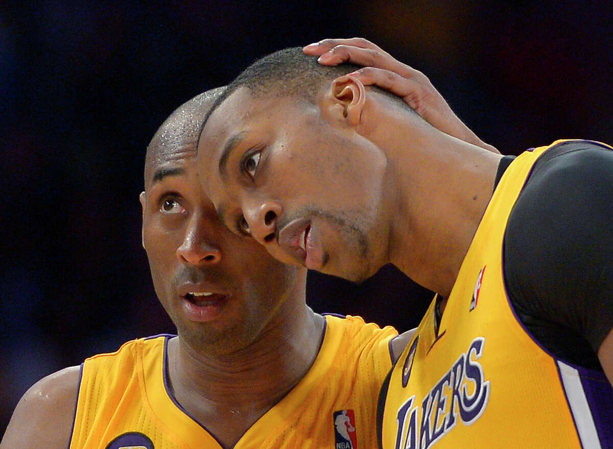 FILE - In this April 5, 2013 file photo, Los Angeles Lakers guard Kobe Bryant, left, hugs center Dwight Howard in the closing seconds of their NBA basketball game against the Memphis Grizzlies in Los Angeles. Howard is being wooed by billboards and by Bryant, while around the NBA teams are beginning to shape their rosters for the next season. (AP Photo/Mark J. Terrill, File)