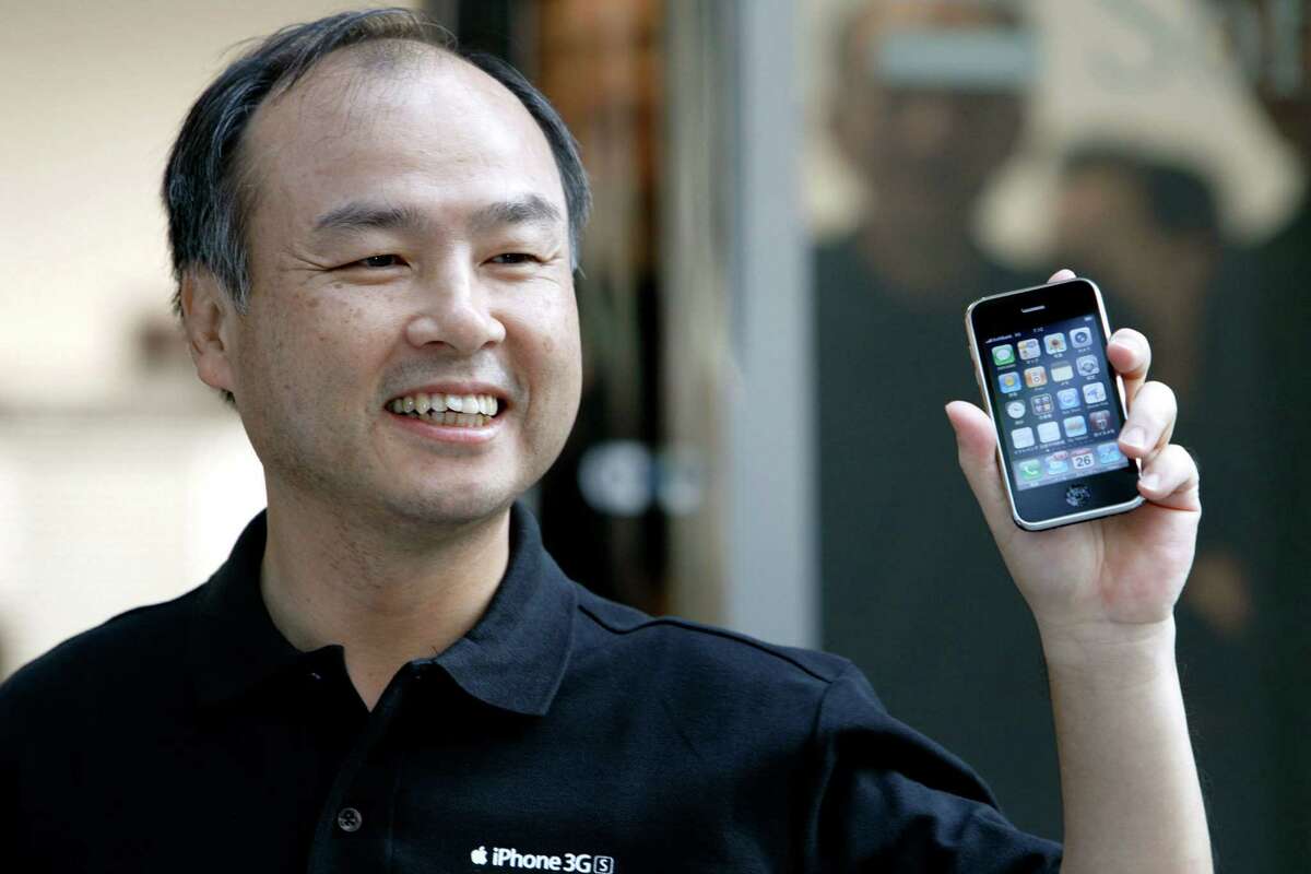 Masayoshi Son, president and chief executive officer of SoftBank Corp., shows the Apple Inc. iPhone 3G S at SoftBank Corp.'s flagship store, in the Omotesando district of Tokyo, Japan, on Friday, June 26, 2009. Apple Inc. started the second phase of the worldwide release of the iPhone 3G S with the handset going on sale today in Japan and Australia. Photographer: Kiyoshi Ota/Bloomberg News shown: hand holding cell phone