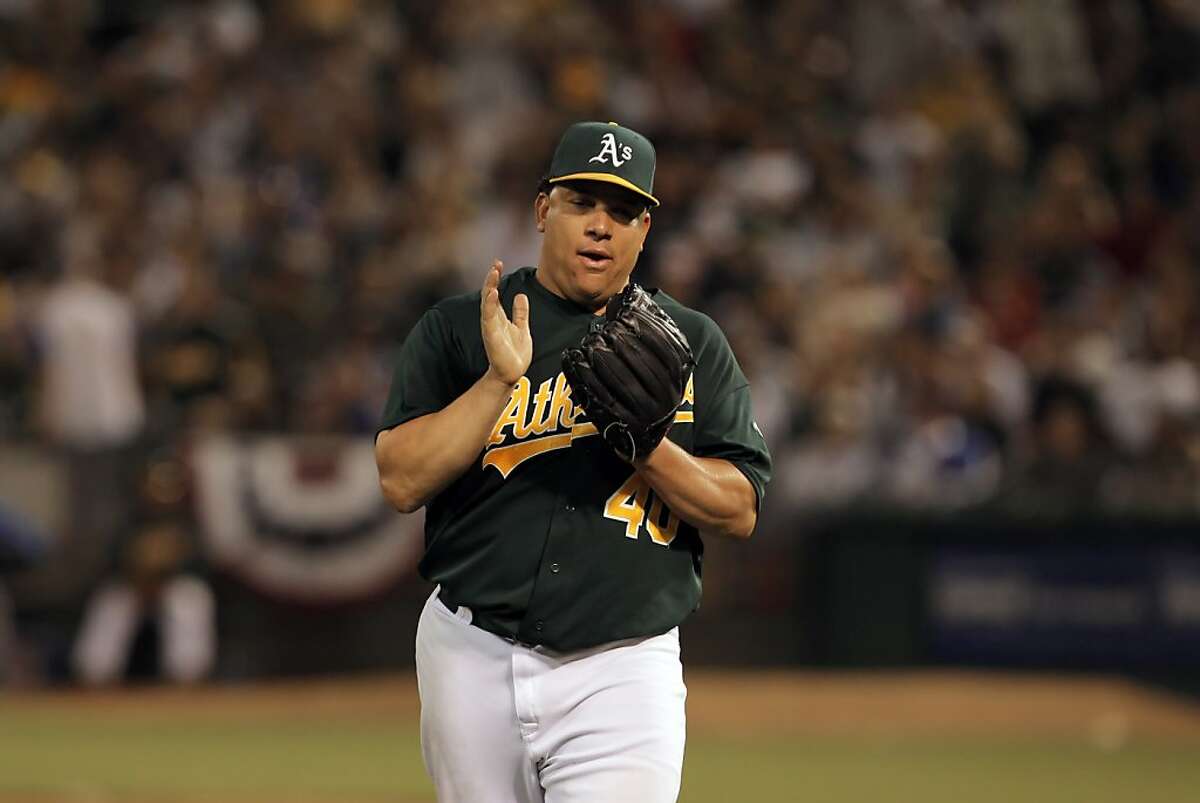 Bartolo Colon applauds a catch by Yoenis Cespedes as Colon works his way out of a jam in the seventh inning. The Oakland Athletics played the Chicago Cubs at O.co Coliseum in Oakland, Calif., on Wednesday, July 3, 2013.