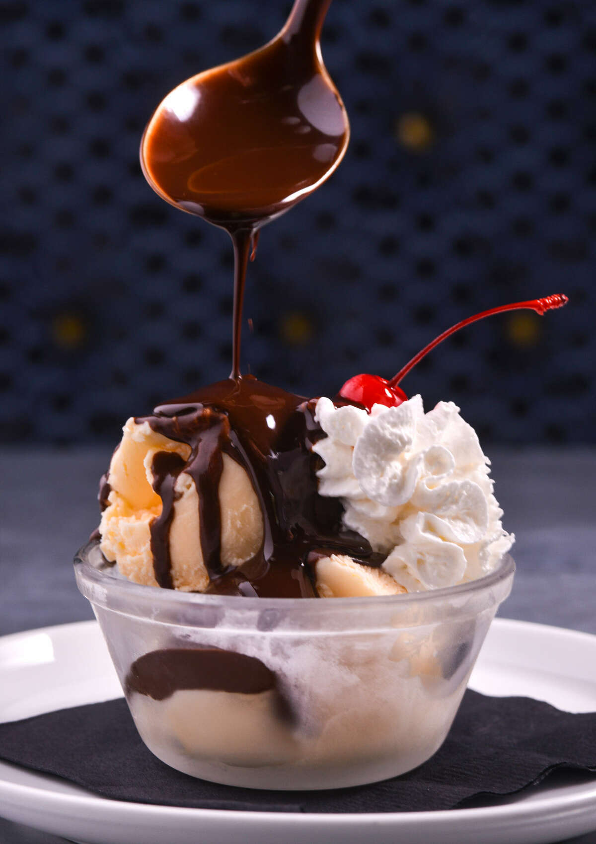 A scoop of vanilla bean ice cream is topped with an espresso-mocha ganache.