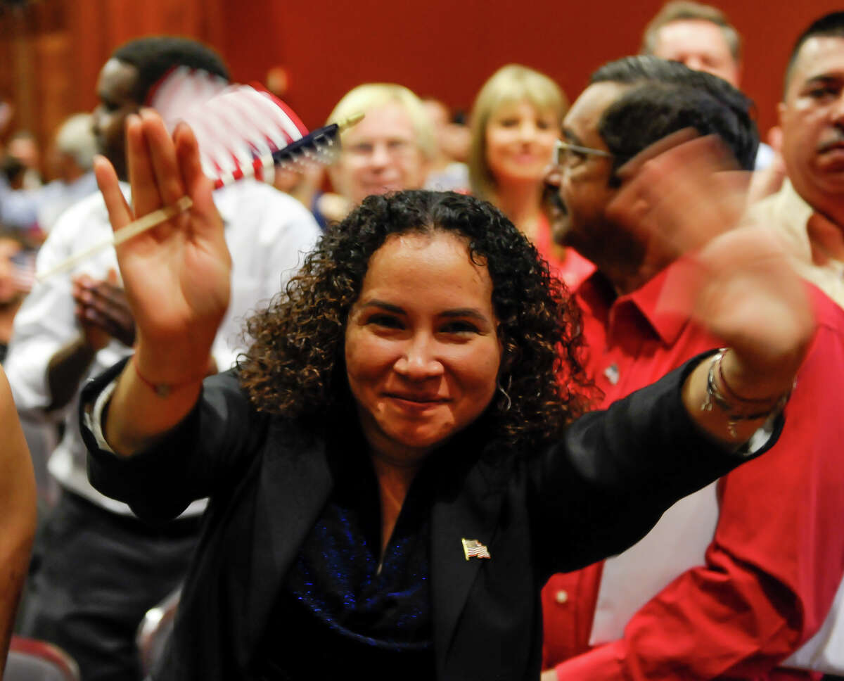 Yanira Villeda waves after being after taking the Naturalization Oath during ceremonies Thursday afternoon at the Henry B. Gonzalez Convention Center.