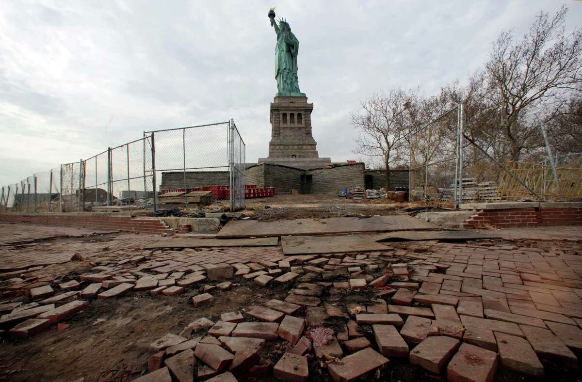 FILE - In a Nov. 30, 2012 file photo, parts of the brick walkway of Liberty Island that were damaged in Superstorm Sandy are shown during a tour of New Yorkâs Liberty Island. After hundreds of National Park Service workers from as far away as California and Alaska spent weeks cleaning and making repairs, the island will reopen to the public on Independence Day, July 4, 2013. (AP Photo/Richard Drew, File)
