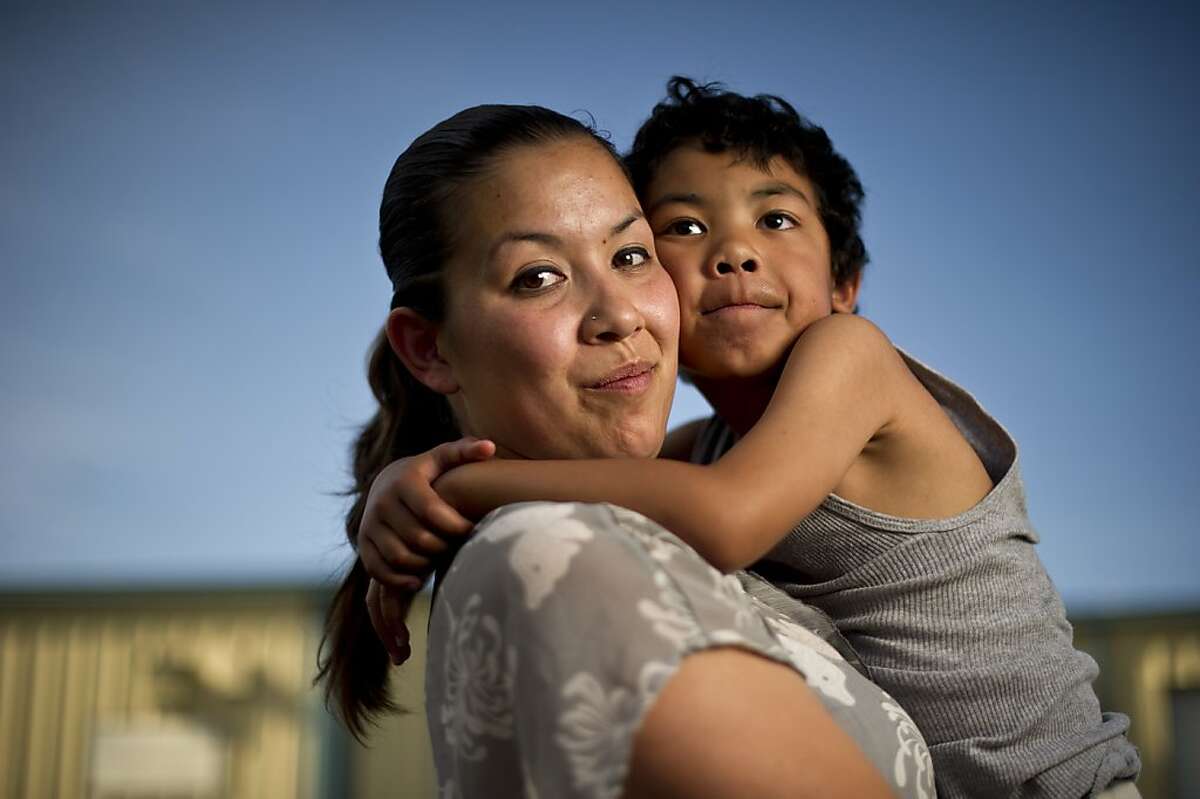 Former prison inmate Crystal Nguyen spends time with her son Neiko Nguyen, 6, on Monday, May 20, 2013, outside the auto detail shop where she works in Pittsburg, Calif.