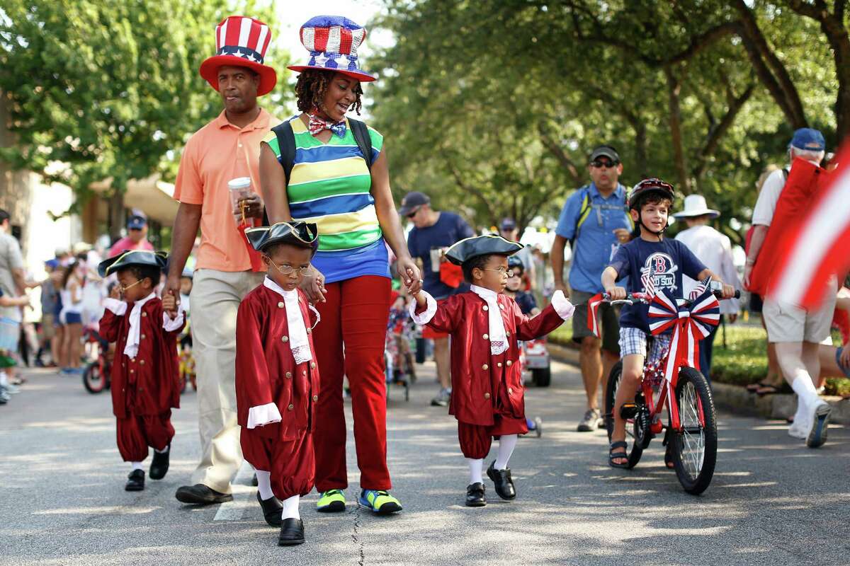 BELLAIRE: Dressed in colonial finery, brothers Quintin, left, Orrin, center, and Shemar Adams escort their parents, Orrin and Marylin Adams, along the Independence Day parade route Thursday in Bellaire.