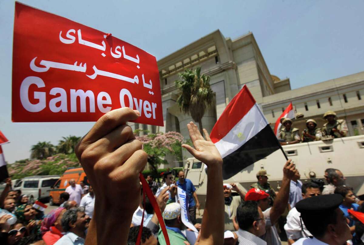Egyptians celebrate in front of the constitutional court after Egypt's chief justice Adly Mansour was sworn in as the nation's interim president Thursday. Arabic reads, " bye bye Morsi." The chief justice of Egypt's Supreme Constitutional Court was sworn in Thursday as the nation's interim president, taking over hours after the military ousted the Islamist President Mohammed Morsi. (AP Photo/Amr Nabil)