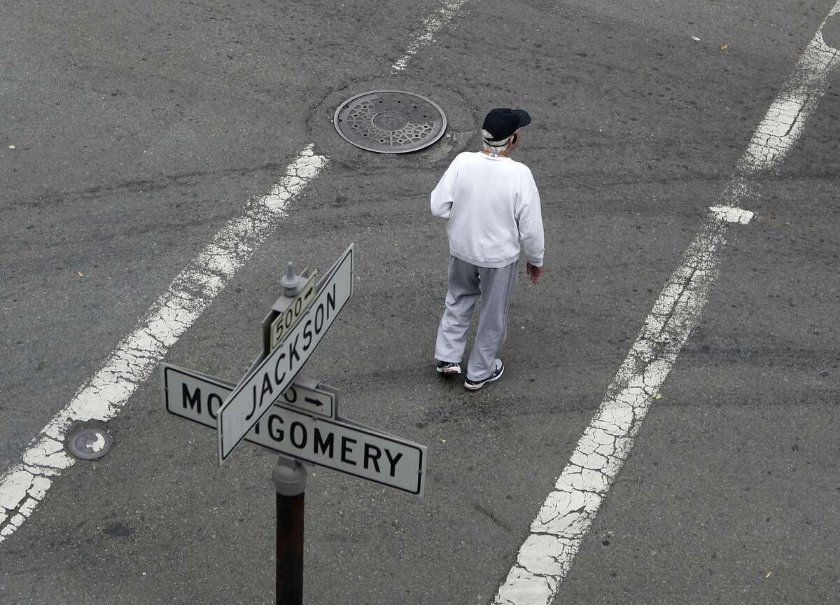 A man crosses Montgomery Street where it intersects Jackson Street in San Francisco, Calif. on Friday, July 5, 2013. A small wooden footbridge once stood where the intersection now is, providing a crossing over a small lagoon for inhabitants during the Gold Rush era.
