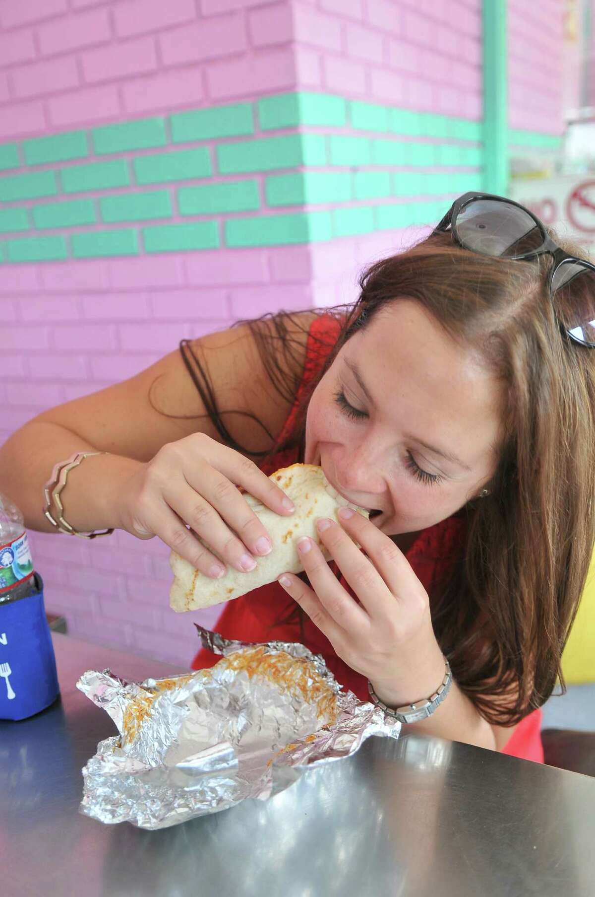 Tour attendee Aimee Witherspoon eating a carne guisada taco at Brothers Taco House.