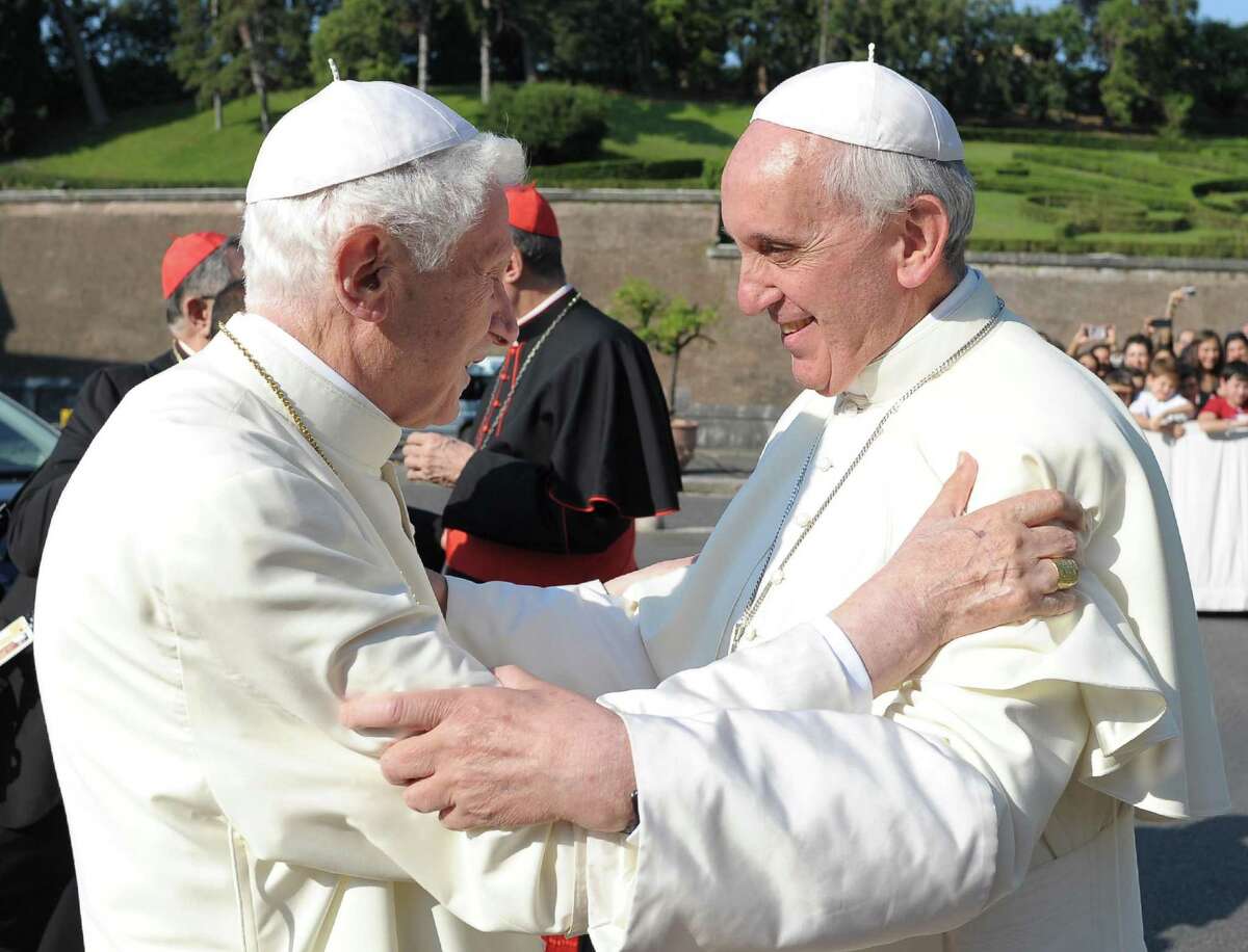 Pope emeritus Benedict XVI, left, is welcomed by Pope Francis during a ceremony for the unveiling of San Michele Arcangelo statue at the Vatican, Friday. Francis and Benedict were together Friday morning for the inauguration of the new monument inside the Vatican gardens ó the first time they have been seen together since May 2, when Francis welcomed Benedict back to the Vatican after his initial retirement getaway. Pope Francis issued his first encyclical Friday, a meditation on faith that is unique because it was written with Benedict XVI. Benedict's hand is evident throughout much of the first three chapters of "The Light of Faith," with his theological style, concerns and reference points clear.
