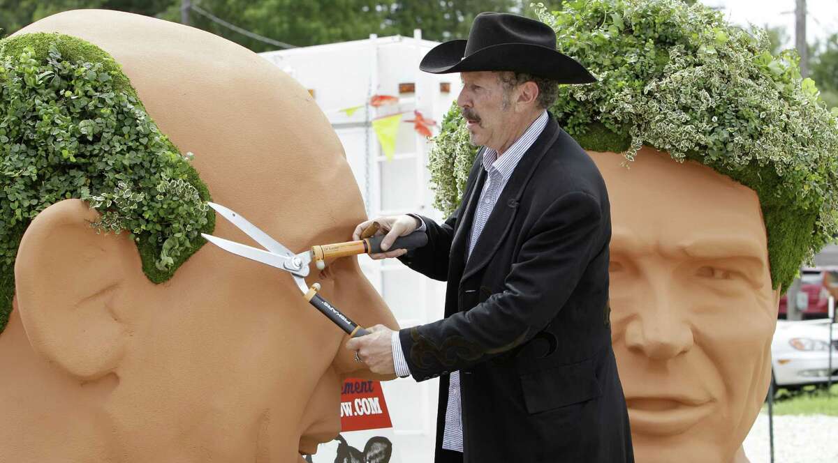 In this 2010 photo, Kinky Friedman trims ivy growing as hair on a 6-foot bust of Democratic gubernatorial candidate Bill White that was part of a publicity stunt in Austin.