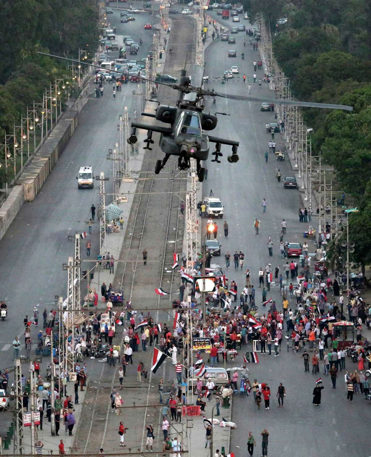 A military attack helicopter flies over a street Friday near the presidential palace, in Cairo, Egypt. The top leader of Egypt's Muslim Brotherhood has vowed to restore ousted President Mohammed Morsi to office, saying Egyptians will not accept "military rule" for another day. General Guide Mohammed Badie, a revered figure among the Brotherhood's followers, spoke Friday before a crowd of tens of thousands of Morsi supporters in Cairo. A military helicopter circled low overhead. (AP Photo/Hassan Ammar)