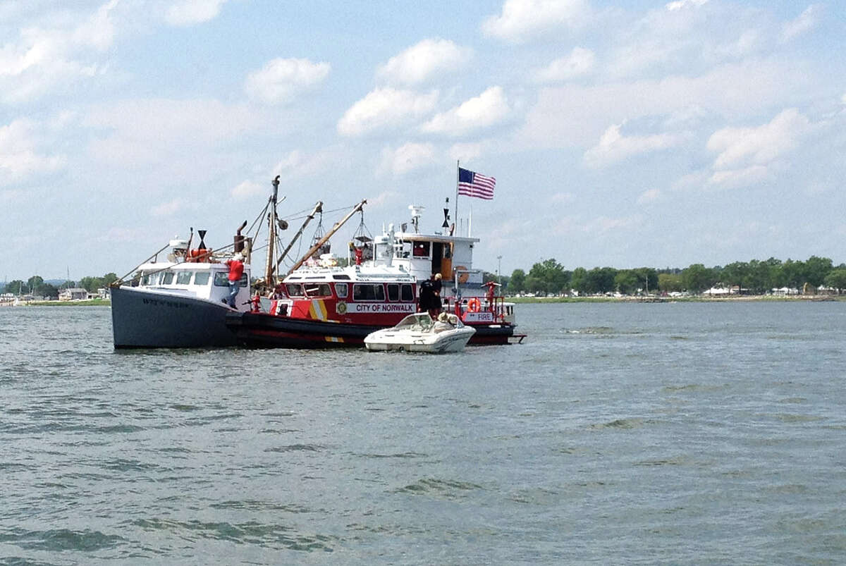 Norwalk and Westport marine patrols assist a small boat that caught fire in Norwalk Harbor in Norwalk, Conn., on Saturday, July 6, 2013.