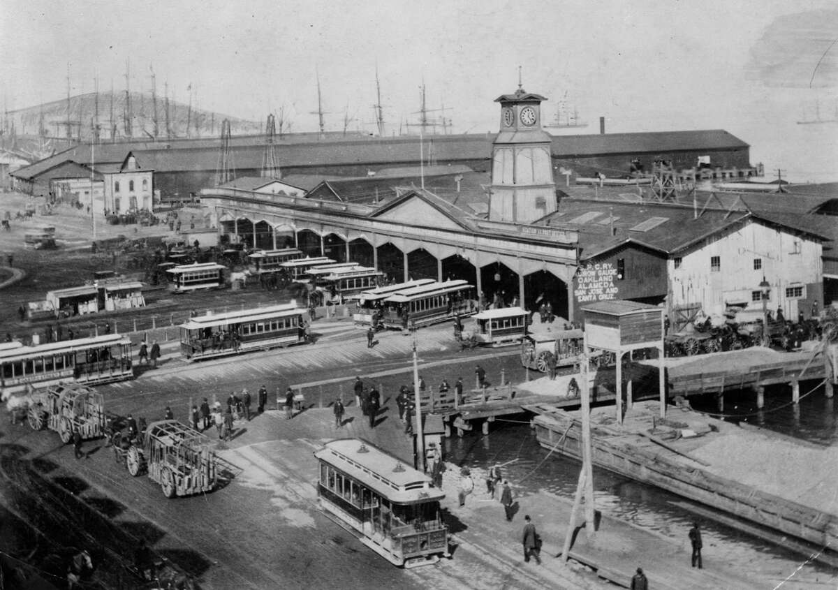 The original Ferry Building. This snub-towered ferry building stood a short distance to the north of its well-known descendant. When the picture was taken in 1886 most cars were cable cars, but a few horse-drawn ones remained. The first ferry sheds were built in 1877.