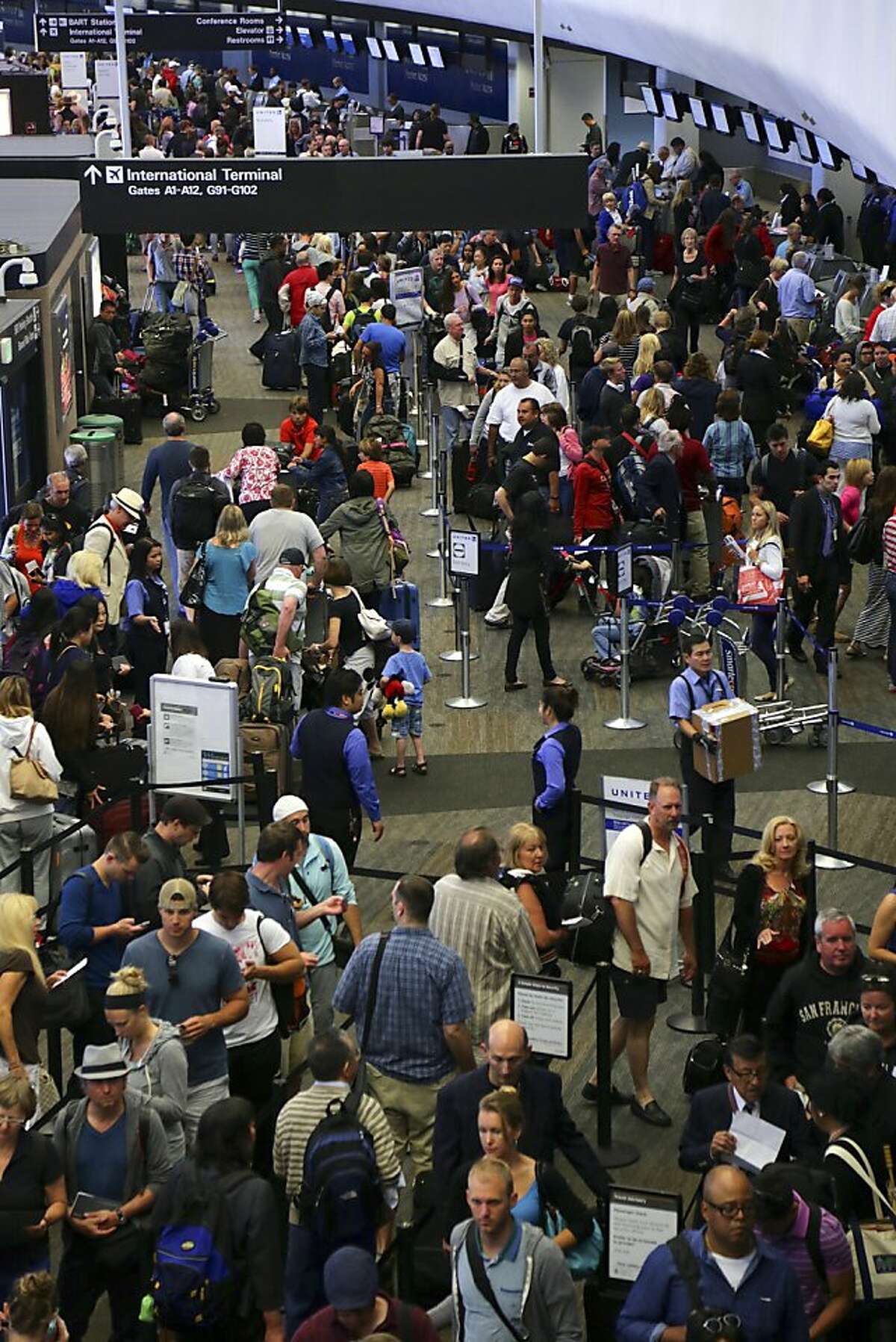 Passengers wait to speak to airline agents in a crowded terminal at San Francisco International Airport a day after the Asiana Airlines flight crash, in San Francisco, July 7, 2013. Two Chinese students were killed in the crash that also left 182 people injured, the authorities said. (Jim Wilson/The New York Times)