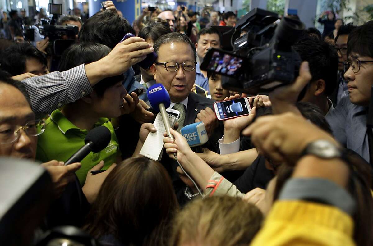 A crush of reporters and photographers meet with Yoon Young-Doo (center), CEO of Asiana Airlines, as he makes a brief comment shortly after his arrival at San Francisco International Airport in Burlingame, Calif. on Tuesday, July 9, 2013. Yoon quickly retreated to a secure area of the international terminal to escape the large crowd of journalists.