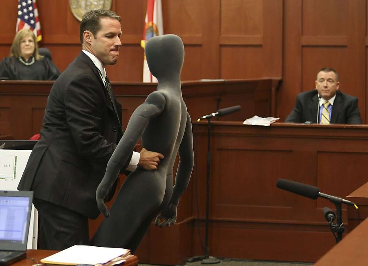 Assistant state attorney John Guy uses a foam dummy to describe the altercation between George Zimmerman and Trayvon Martin to defense witness and law enforcement expert Dennis Root during Zimmerman's trial in Seminole circuit court, in Sanford, Florida, Wednesday, July 10, 2013. Zimmerman is charged with second-degree murder in the fatal shooting of Trayvon Martin, an unarmed teen, in 2012. (Pool photo by Gary W. Green/Orlando Sentinel/MCT)