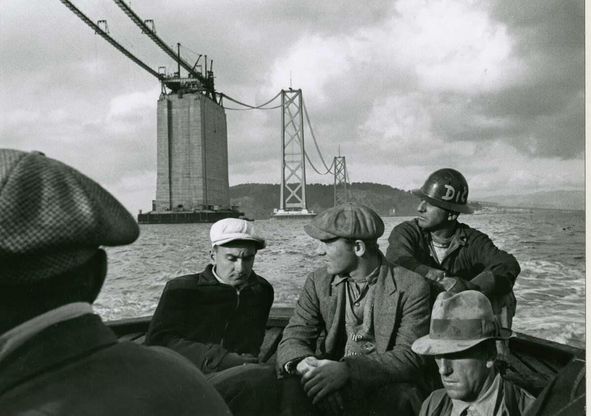 1935年，原海湾大桥一天的建设工作结束后，人们乘船回家。