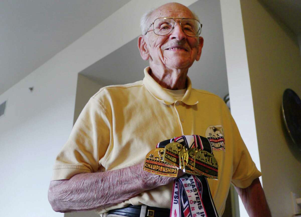 Orville Rogers shows off some of the medals he's won at track and field competitions, July 8, 2013. The 95-year-old has only competed at master's events for the last five years. (AP Photo/John L. Mone)