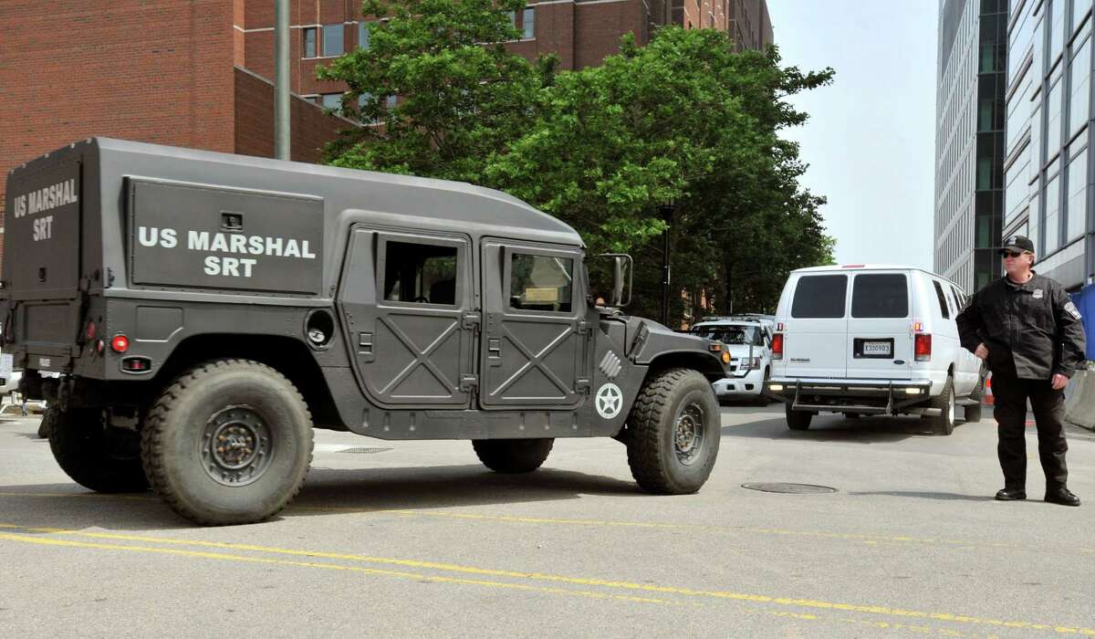 A U.S. Marshal's van, right, believed to be carrying Boston Marathon bombing suspect Dzhokhar Tsarnaev, arrives at the federal courthouse for his arraignment Wednesday, July 10, 2013, in Boston. The April15 attack killed three and wounded more than 260. The 19-year-old Tsarnaev has been charged with using a weapon of mass destruction, and could face the death penalty. (AP Photo/Josh Reynolds)