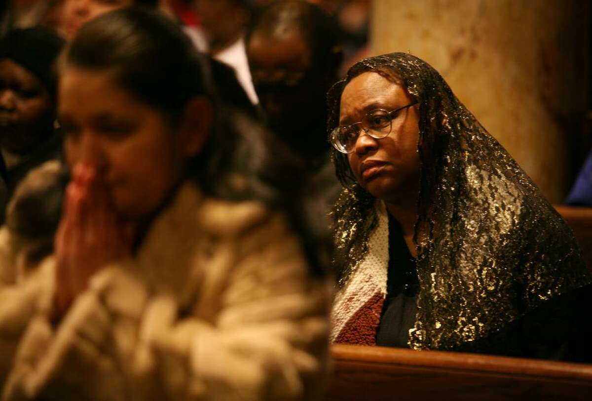 Barbara Rickman, right of Shelton, attends the memorial service for victims of the Haitian earthquake at St. Charles Borromeo Church in Bridgeport on Monday, January 18, 2010.