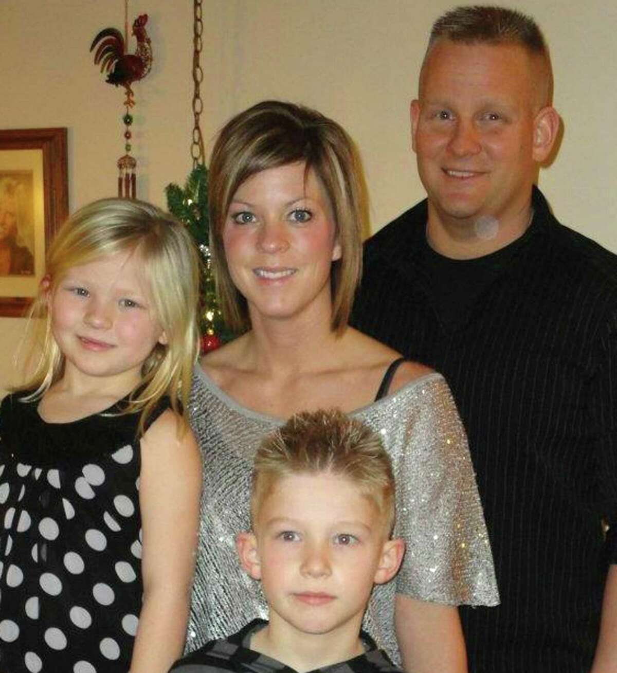 Dental assistant Melissa Nelson, shown with her family, was fired at the dentist's wife's request.