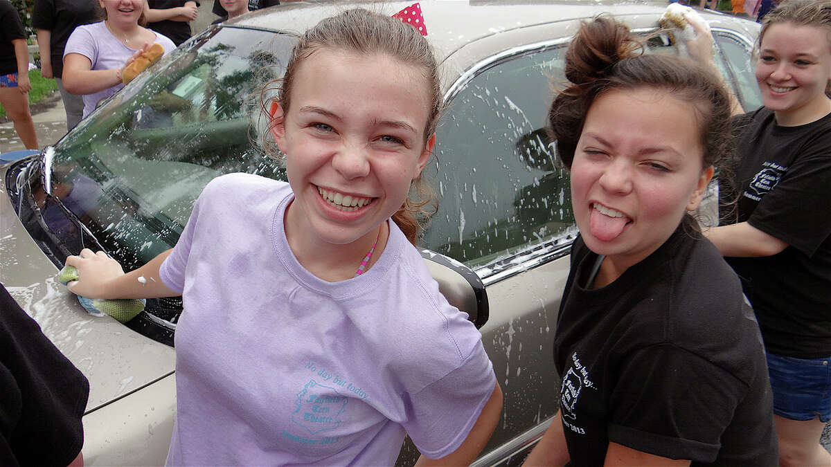 Emma LaPlace and Tess Manderville get goofy while washing cars at the Fairfield Teen Theater's car wash Saturday at Fairfield Woods Middle School.