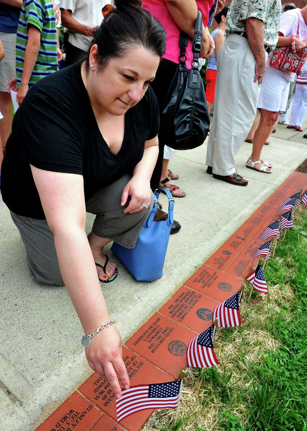 Amy Fagnani, of Danbury, visits the the bricks honoring her husband and two grandfathers, as the Veterans Walkway of Honor dedication ceremony takes place at the Danbury War Memorial, in Danbury, Conn. Sunday, July 14, 2013.