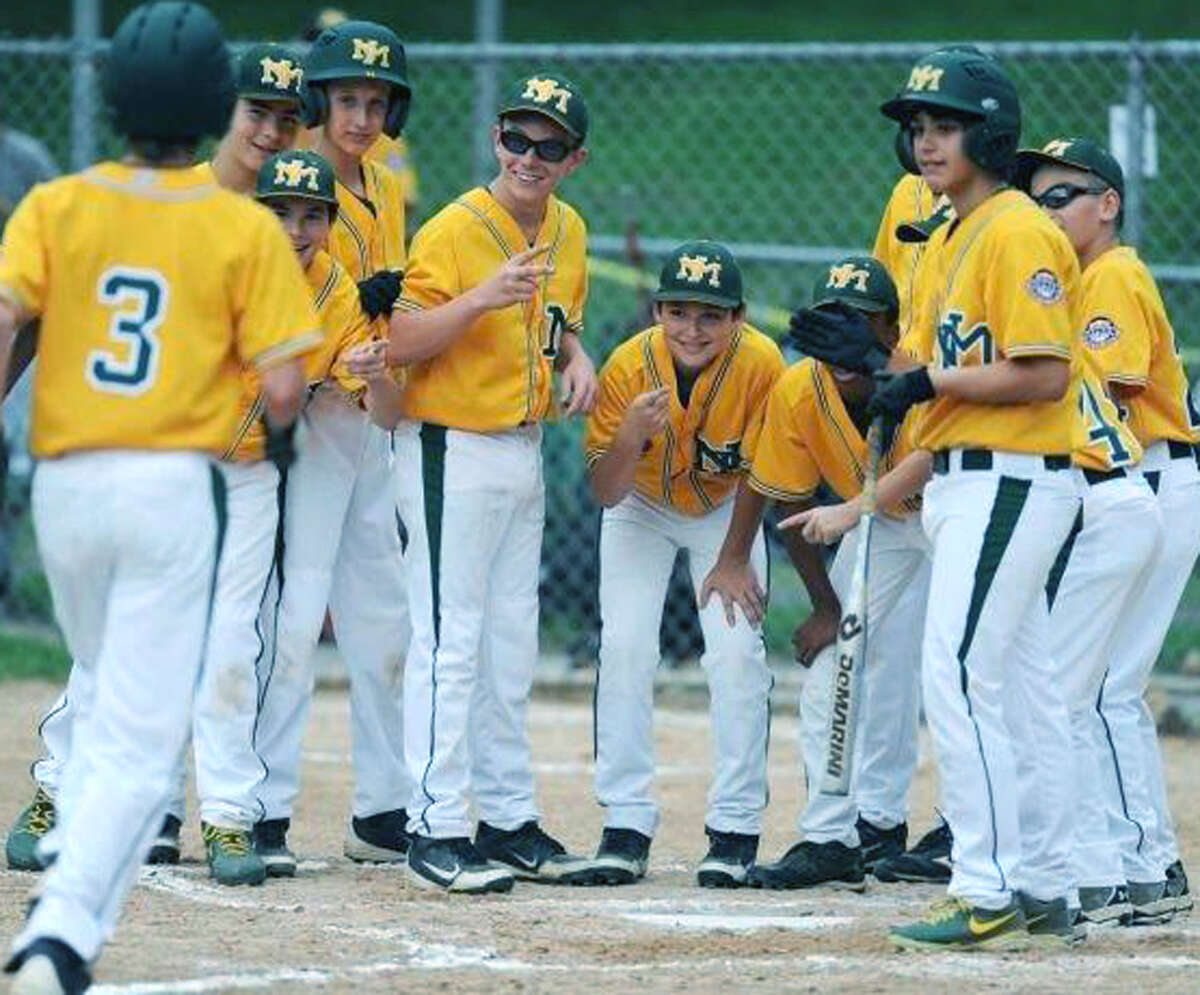 Chris Gesualdi of the Thunder is greeted by his teammates following a home run during the New Milford youths' 10-0 victory over Danbury in the Cal Ripken 12-year-olds' state tournament championship game in Southbury. July 12, 2013 Photography by Tyler Sizemore
