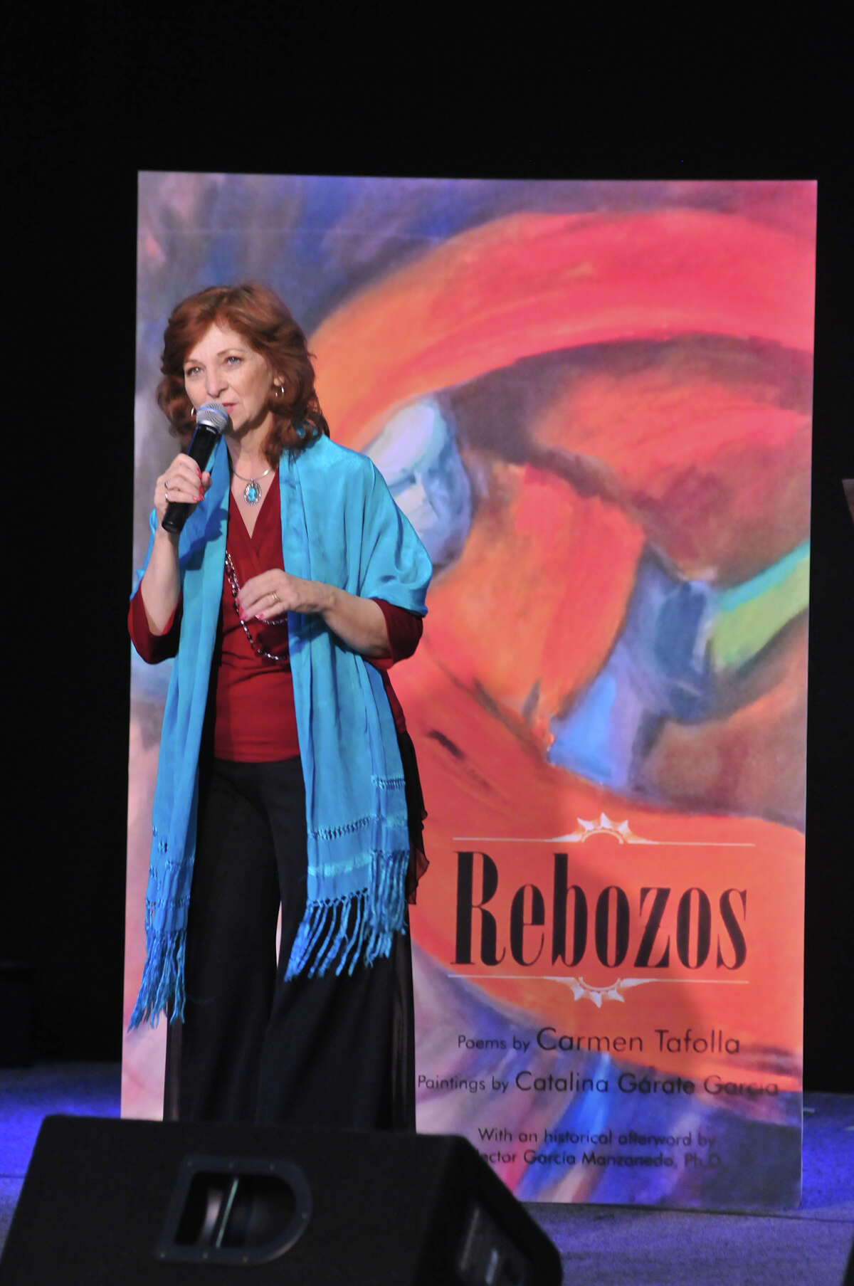 San Antonio author and Poet Laureat Carmen Tafolla speaks in front of an enlargement of her book, Rebozos, during the 9th annual San Antonio Express-News Children's Book Celebration.